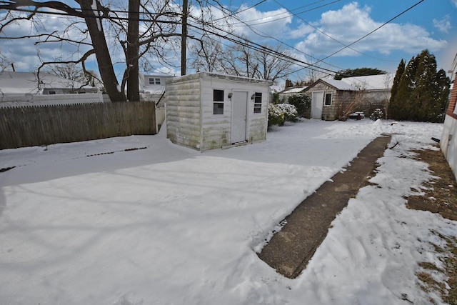 yard covered in snow featuring a shed