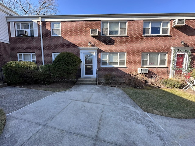 view of front of house featuring cooling unit and a front yard