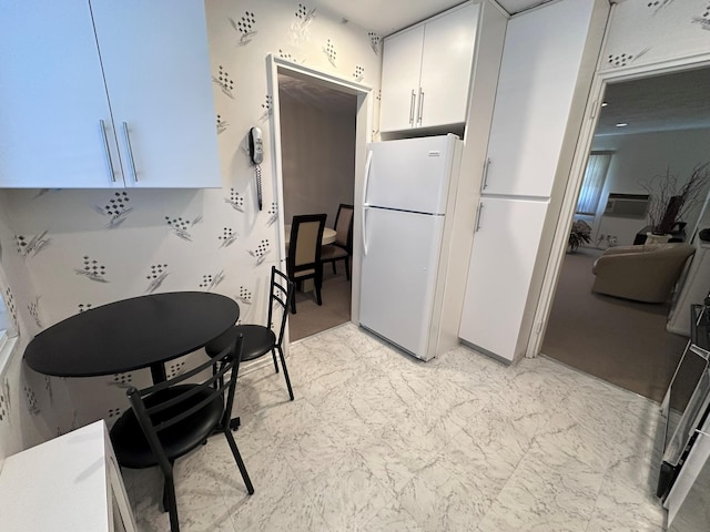 kitchen featuring white cabinets and white refrigerator