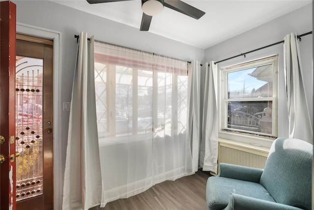 sitting room with hardwood / wood-style floors and ceiling fan