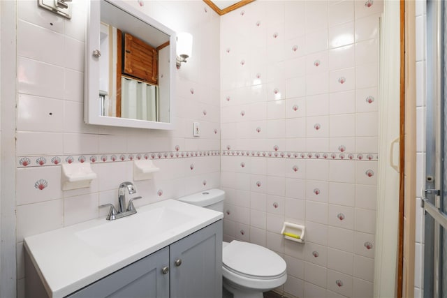 bathroom with vanity, tile walls, and toilet