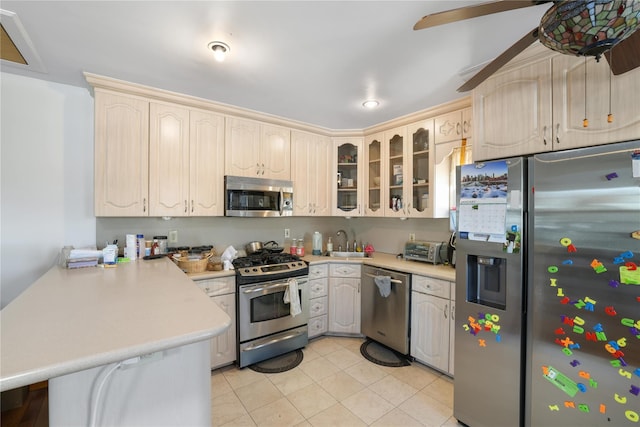 kitchen with sink, ceiling fan, appliances with stainless steel finishes, light tile patterned flooring, and kitchen peninsula