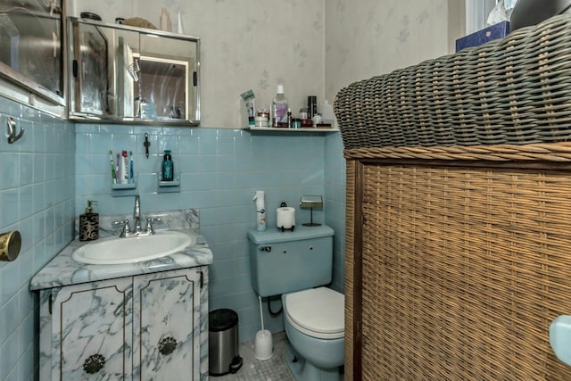 bathroom featuring vanity, tile walls, tile patterned floors, and toilet