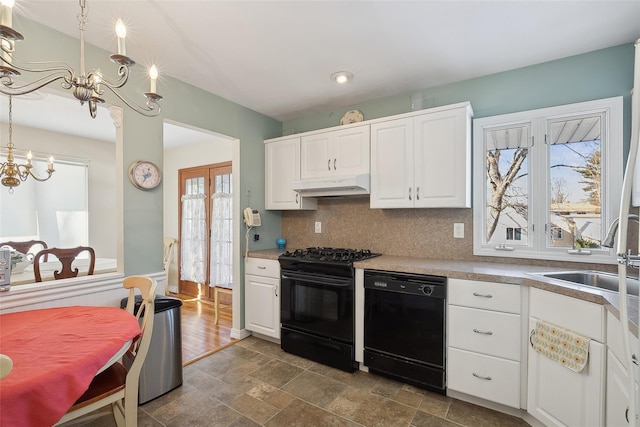 kitchen featuring pendant lighting, white cabinets, and black appliances