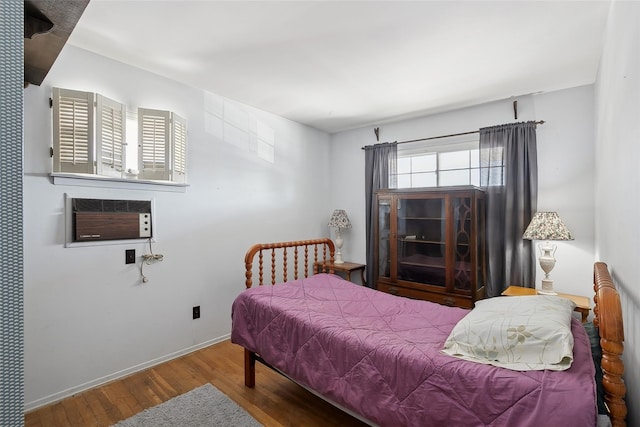 bedroom featuring a wall mounted air conditioner and hardwood / wood-style floors