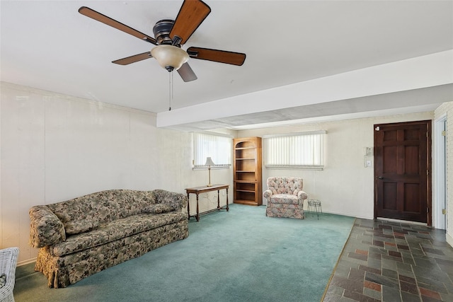 sitting room with ceiling fan and dark carpet