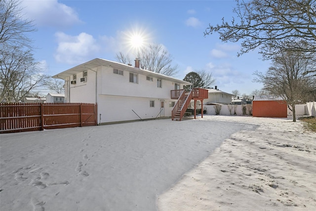 back of house featuring a deck and a storage shed