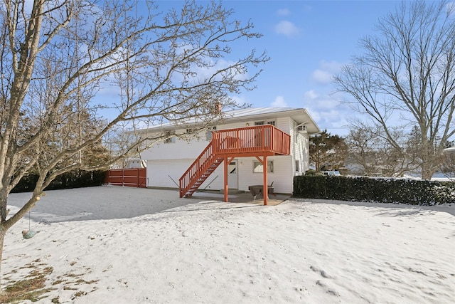 snow covered back of property featuring a wooden deck