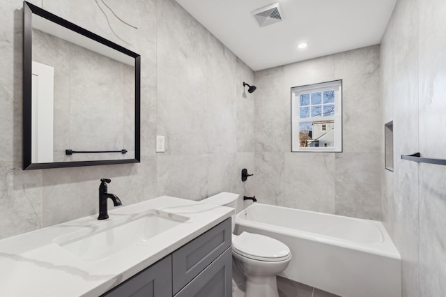 full bathroom featuring bathtub / shower combination, vanity, toilet, and tile walls