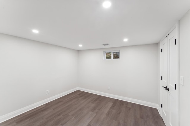 basement with dark hardwood / wood-style floors