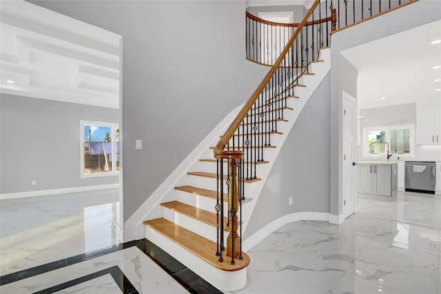 staircase featuring sink and a healthy amount of sunlight