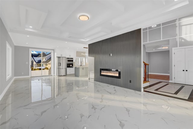 unfurnished living room with sink, wooden walls, and a fireplace