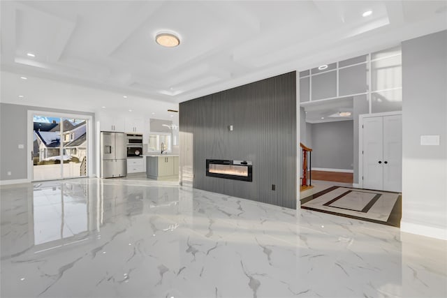 unfurnished living room with a large fireplace and a raised ceiling