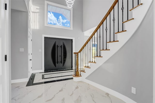 foyer entrance featuring a towering ceiling