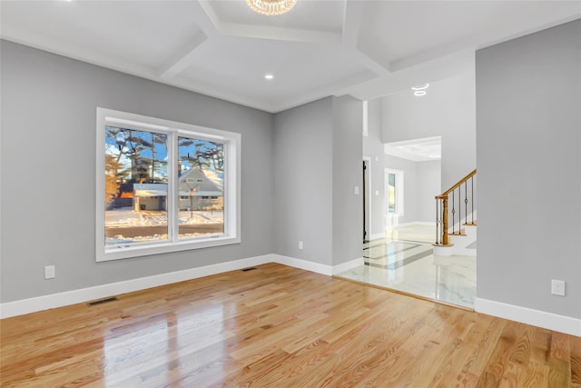 unfurnished living room with light hardwood / wood-style floors and a notable chandelier