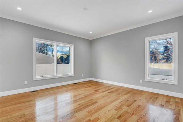 empty room with light wood-type flooring and crown molding