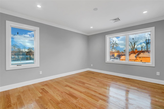 unfurnished room with light hardwood / wood-style floors and crown molding