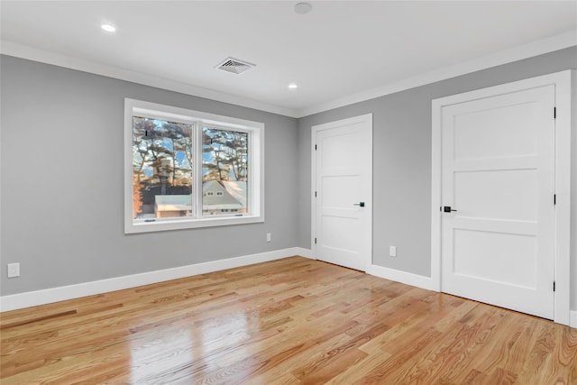 unfurnished bedroom featuring light wood-type flooring and crown molding