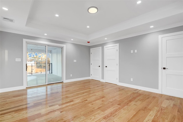 unfurnished bedroom with light hardwood / wood-style floors, crown molding, a tray ceiling, and access to outside