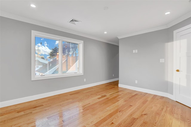 spare room with crown molding and light wood-type flooring