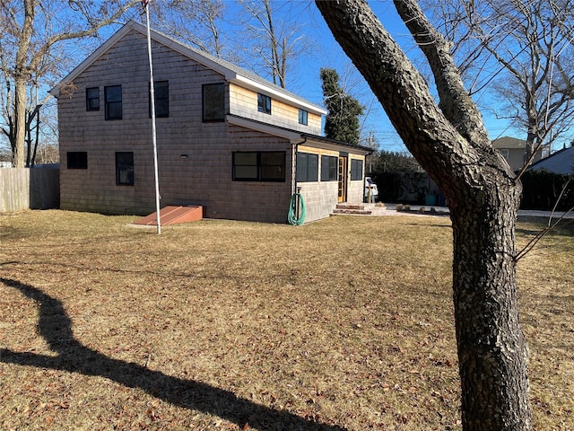 rear view of house with a yard and fence