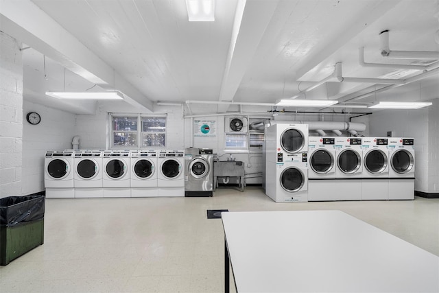 clothes washing area with washing machine and dryer, stacked washer / drying machine, and sink