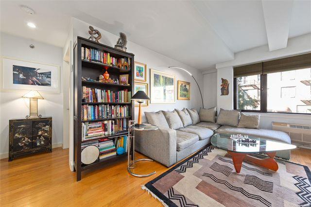 living room with beamed ceiling, radiator, and wood-type flooring