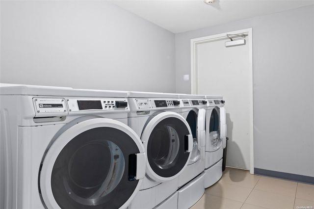 laundry area featuring light tile patterned flooring and washer and clothes dryer