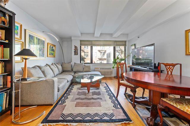 living room with light hardwood / wood-style flooring and beamed ceiling