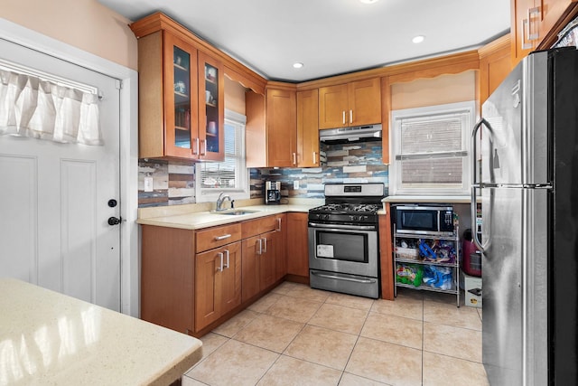 kitchen featuring light tile patterned floors, appliances with stainless steel finishes, sink, and backsplash