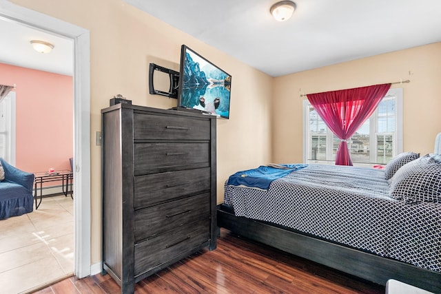 bedroom with hardwood / wood-style flooring and baseboard heating