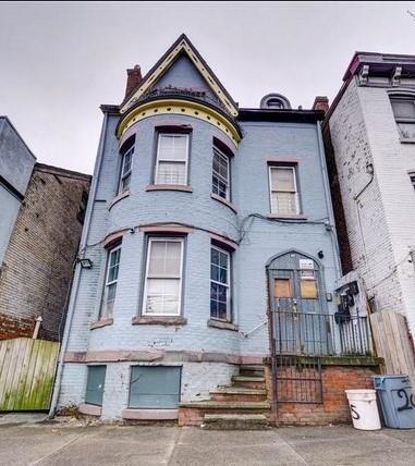 victorian house featuring fence and a chimney