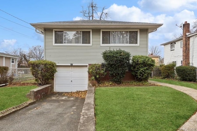 view of front of property featuring a garage and a front lawn