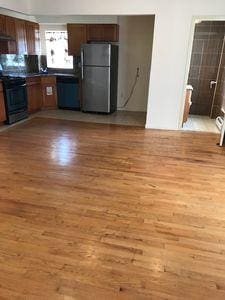 kitchen with dark countertops, black appliances, and wood finished floors