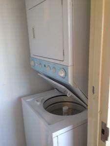 clothes washing area featuring stacked washer / drying machine