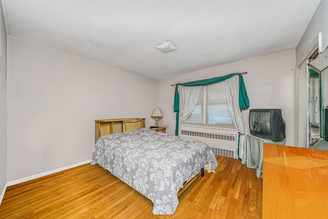 bedroom with radiator and wood-type flooring