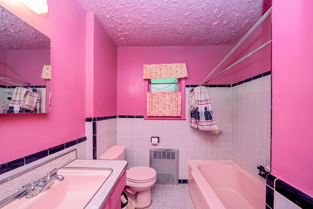 full bathroom with toilet, radiator, a textured ceiling, tile walls, and tile patterned flooring