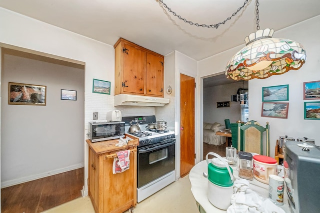 kitchen with decorative light fixtures, backsplash, and gas range