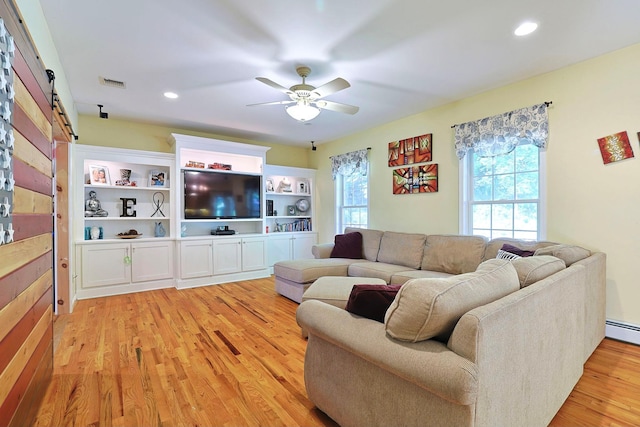 living room featuring a barn door, ceiling fan, and light wood-type flooring