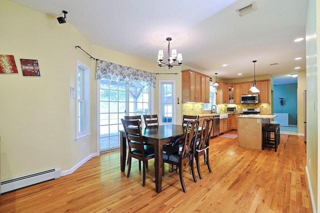 dining room with an inviting chandelier, sink, light hardwood / wood-style flooring, and baseboard heating