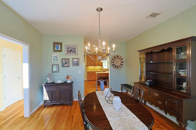 dining area with a notable chandelier and light hardwood / wood-style floors