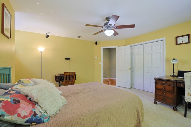 carpeted bedroom with ceiling fan and a closet