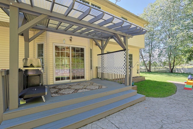 exterior space featuring a wooden deck, a patio, a pergola, and a lawn