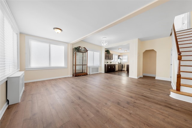 unfurnished living room with a healthy amount of sunlight and wood-type flooring