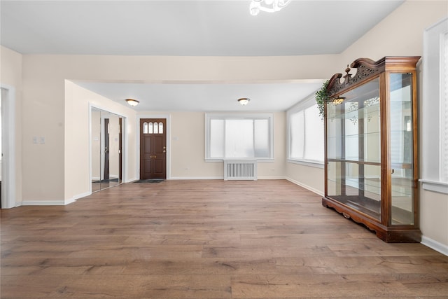 foyer entrance with radiator and light wood-type flooring