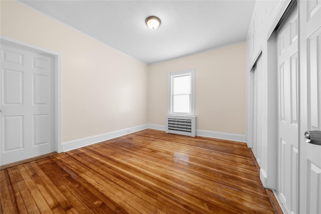 unfurnished bedroom featuring radiator and wood-type flooring