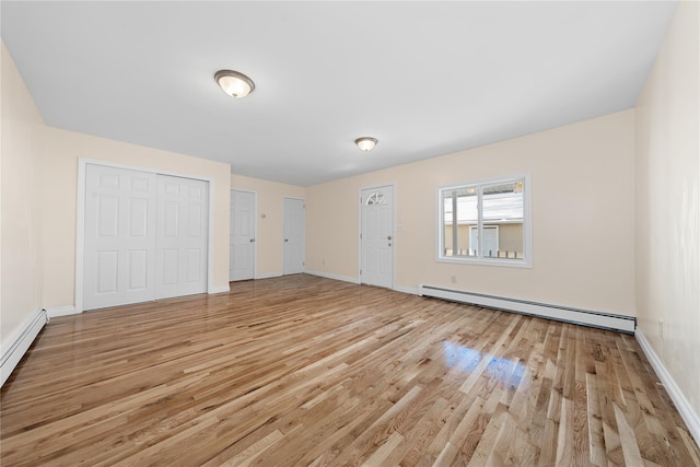 interior space featuring baseboard heating and light wood-type flooring