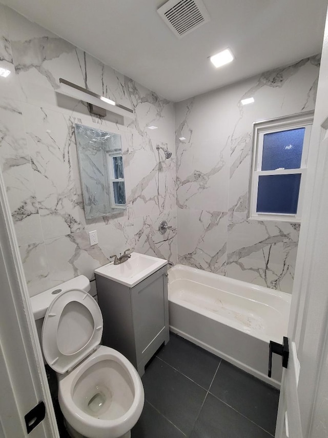 full bathroom with toilet, shower / bathing tub combination, tile walls, tile patterned floors, and vanity