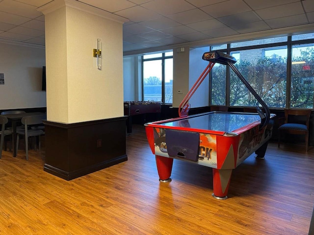 game room featuring hardwood / wood-style flooring, a paneled ceiling, and crown molding