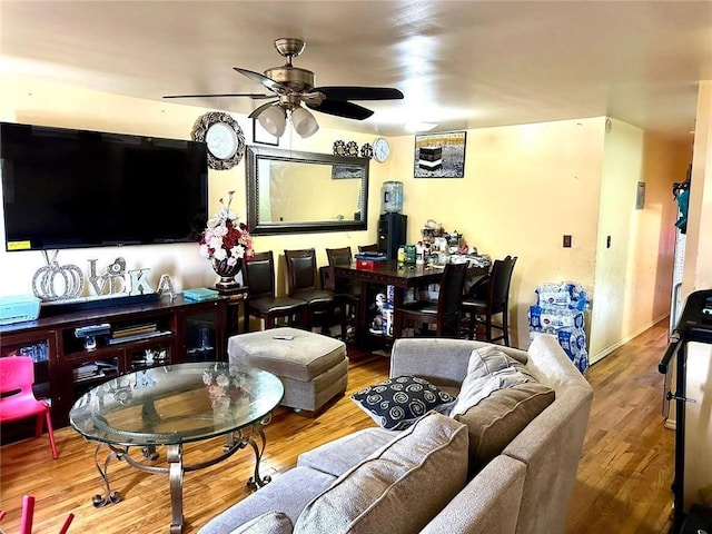 living room featuring wood-type flooring and ceiling fan